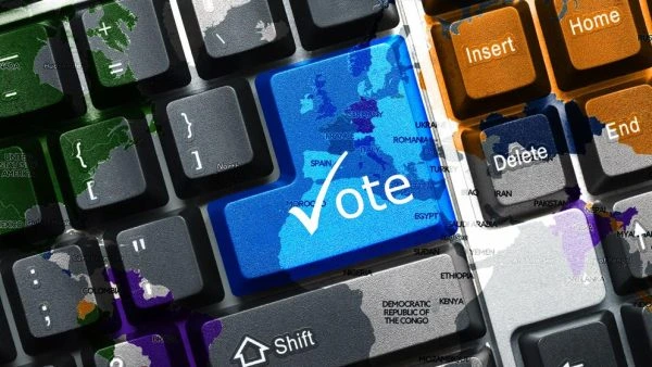 Botón virtual de votación sobre un teclado, representando el sistema de votaciones digitales en asambleas virtuales de Santel Televisión